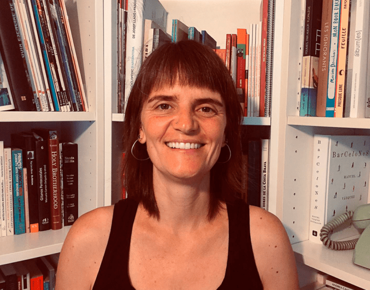 Clara posa delante de su librería